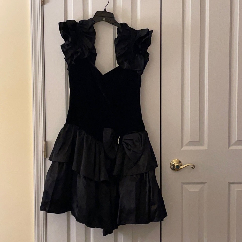 Black Ruffled sleeve and skirt evening dress with rhinestone embellished bow.